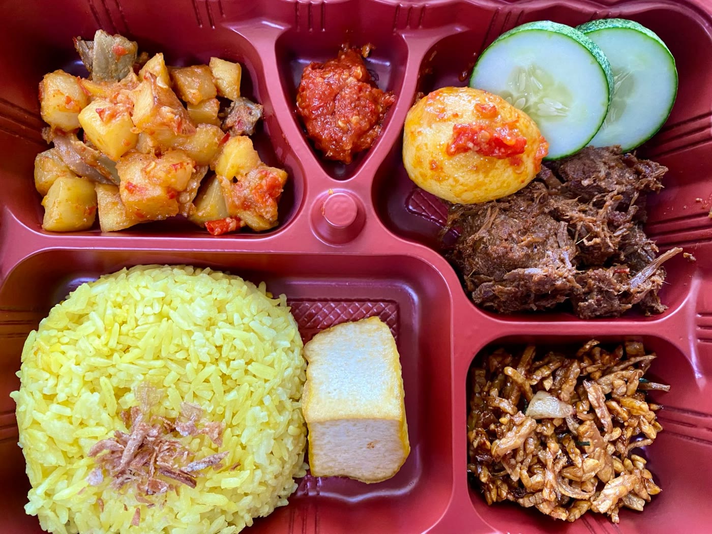 Set A bento: yellow rice, beef rendang, egg balado, potato balado with chicken gizzard and petai, tempe with bilis, yellow tofu, sambal