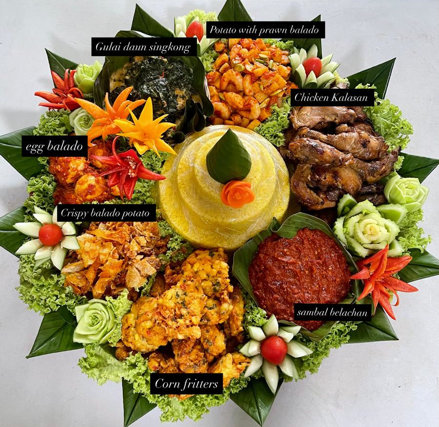 Tumpeng with yellow rice, labelled: chicken kalasan, egg balado, potato with prawn balado, gulai daun singkong, crispy balado potato, corn fritters, sambal belacan