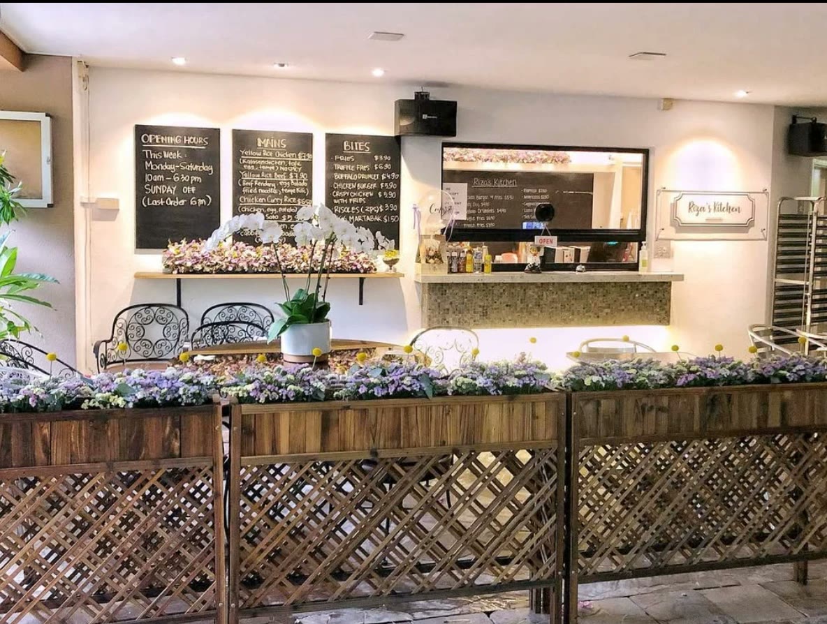 The former Riza's Kitchen café, with chalkboard menus, a serving counter and wooden flower planters