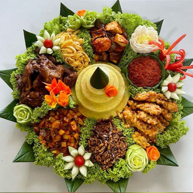 Round tumpeng tray with yellow rice cone, chicken, shredded egg, sambal and fritters